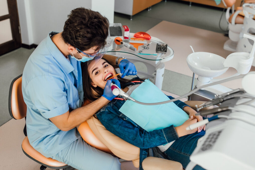 young female patient with open mouth examining dental inspection at dentist office wondering whatto ask orthodontist before getting braces